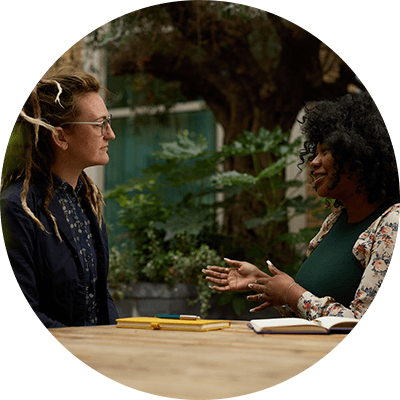 A close up shot of two women talking at a table.