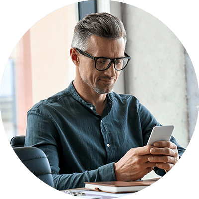 A man at a desk looking at his phone.