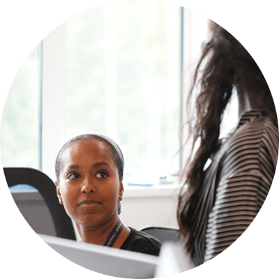 Two colleagues discussing work at a desk